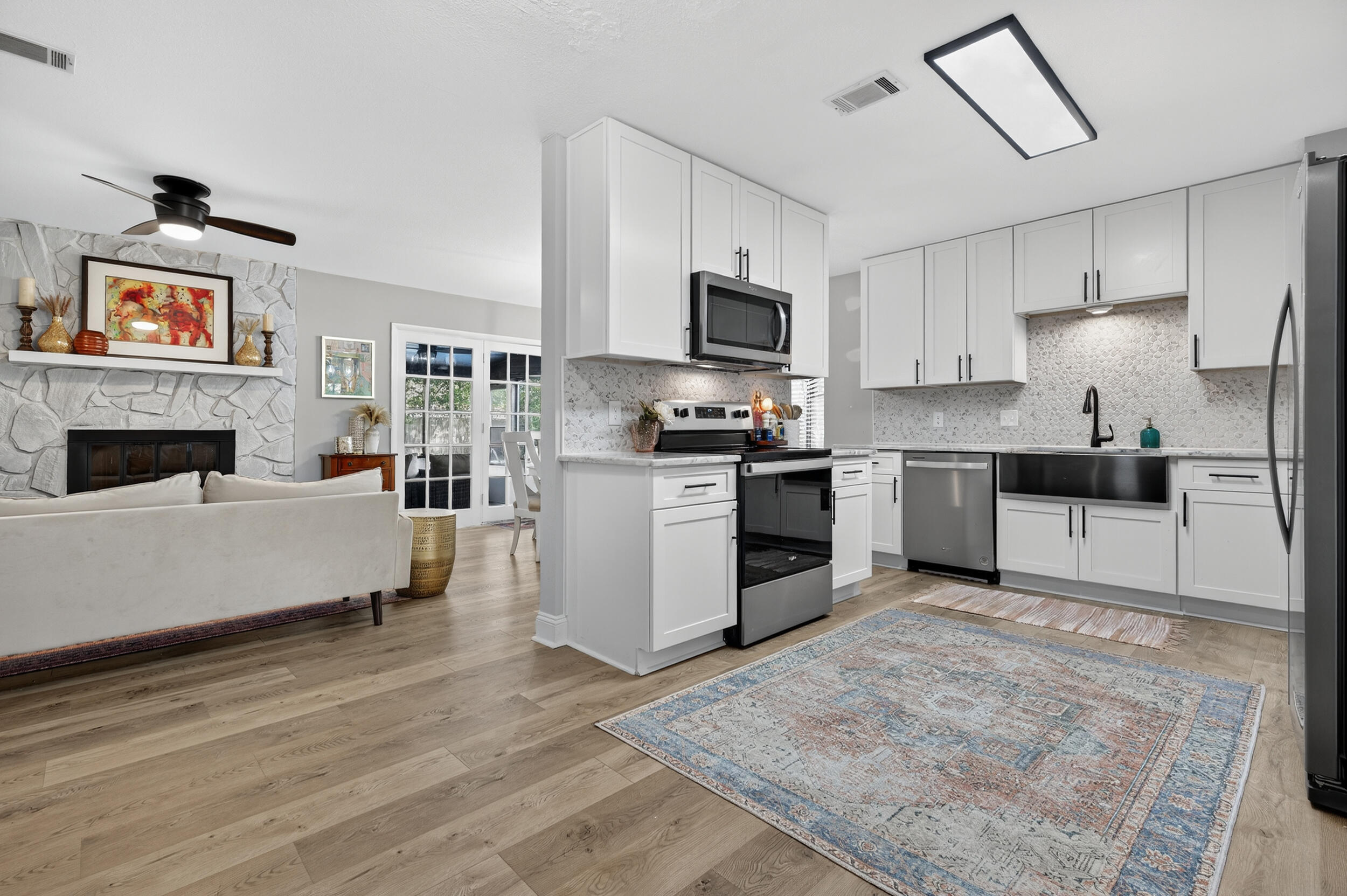 370 Edge Avenue Valparaiso, FL 32580 - Photo 4 of 58 a large white kitchen with stainless steel appliances granite countertop a stove top oven a sink dishwasher and a refrigerator with wooden floor