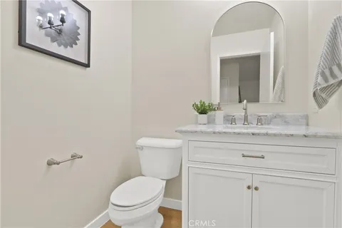 a bathroom with a granite countertop toilet sink and mirror