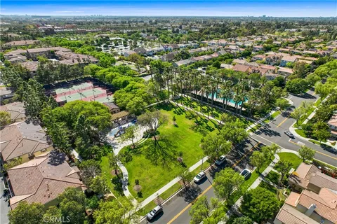 an aerial view of residential houses with outdoor space and trees