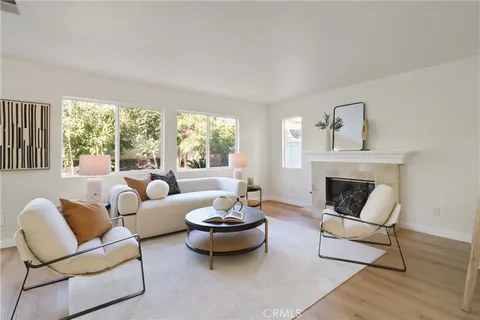 a living room with furniture a fireplace and a large window