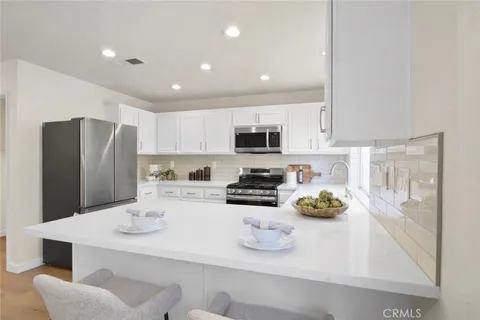 a kitchen with stainless steel appliances a refrigerator sink stove microwave and cabinets