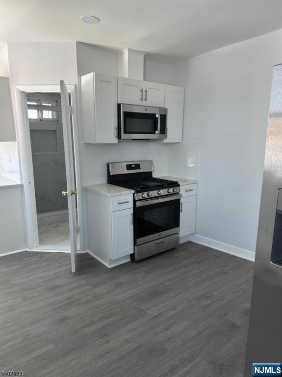 105 Broadway Newark, NJ 07104 - Photo 4 of 9 a kitchen with stainless steel appliances a refrigerator stove and microwave