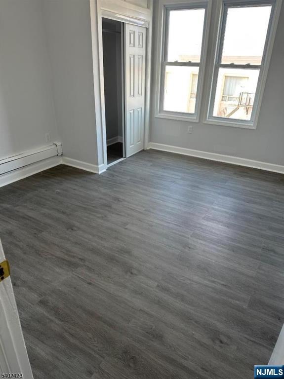 105 Broadway Newark, NJ 07104 - Photo 7 of 9 an empty room with wooden floor and windows
