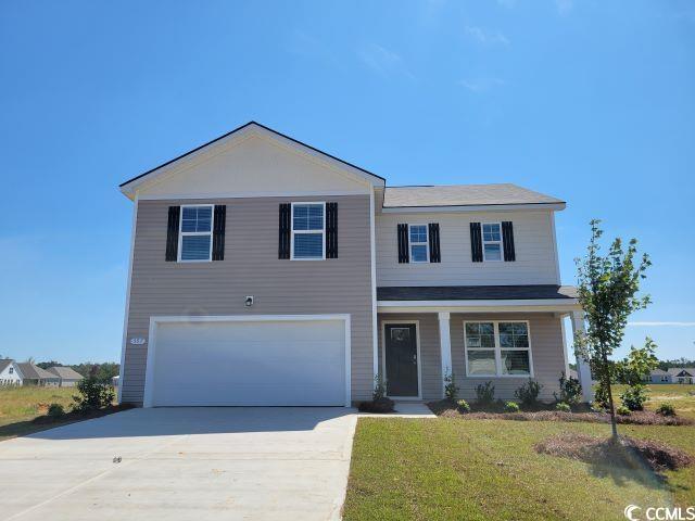 View of front facade with a porch, driveway, a garage, and a front lawn