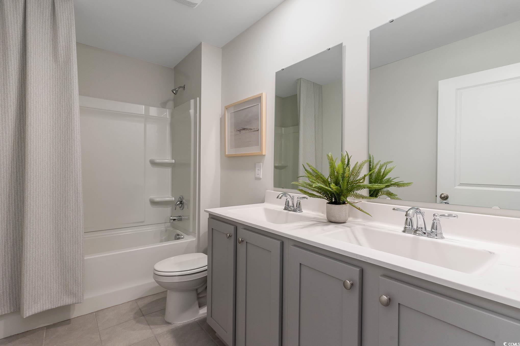357 Acosta Circle Conway, SC 29527 - Photo 26 of 27 Bathroom with double vanity, shower / bathtub combination with curtain, toilet, and tile patterned floors