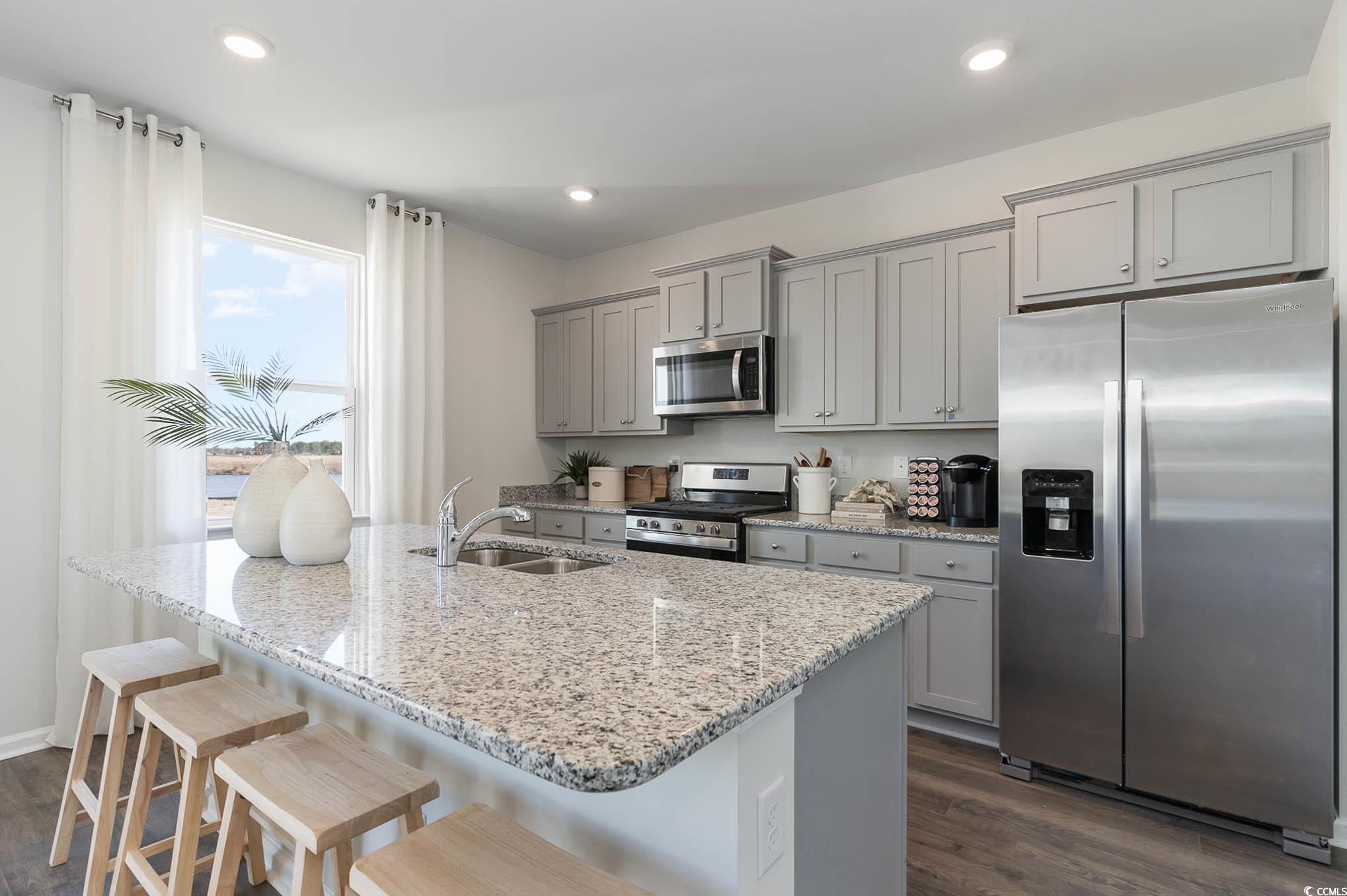 357 Acosta Circle Conway, SC 29527 - Photo 7 of 27 Kitchen with stainless steel appliances, a sink, gray cabinetry, dark wood-style floors, and a breakfast bar area