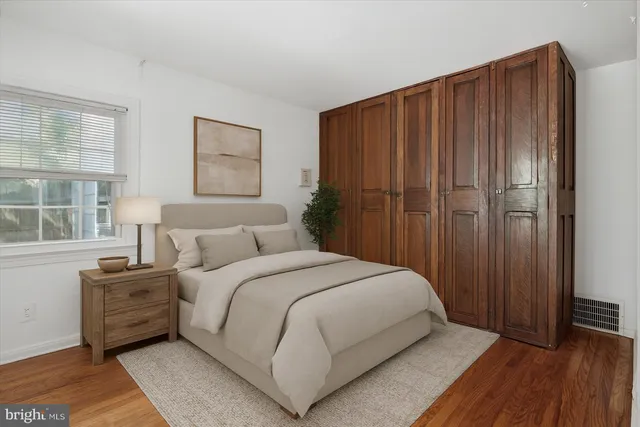 a large bedroom with a bed and wooden floor