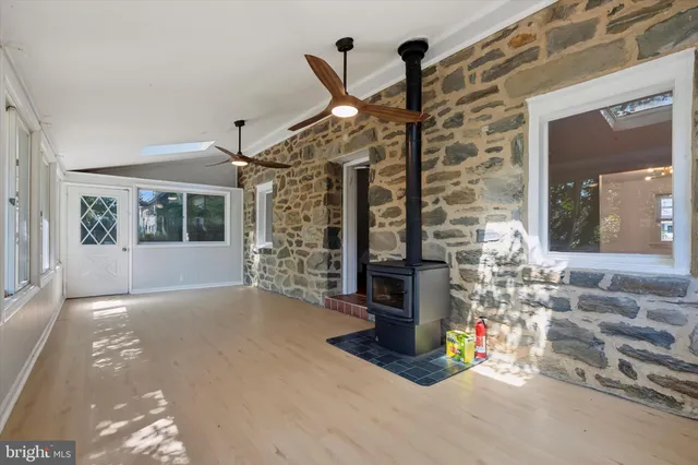 a view of empty room with floor to ceiling window and fireplace