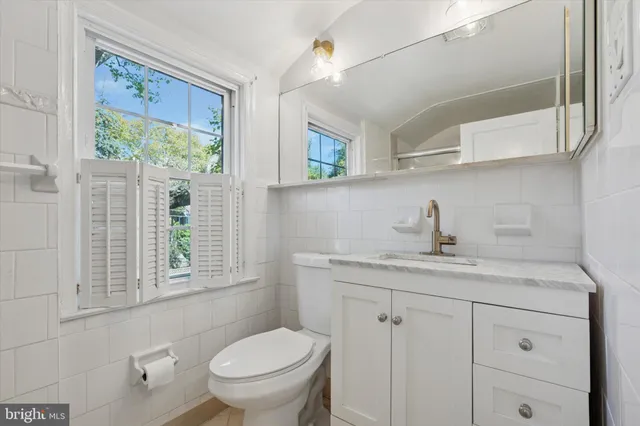 a bathroom with a sink a toilet and a window