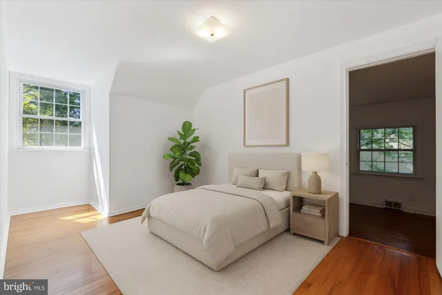 a bedroom with a bed and a potted plant