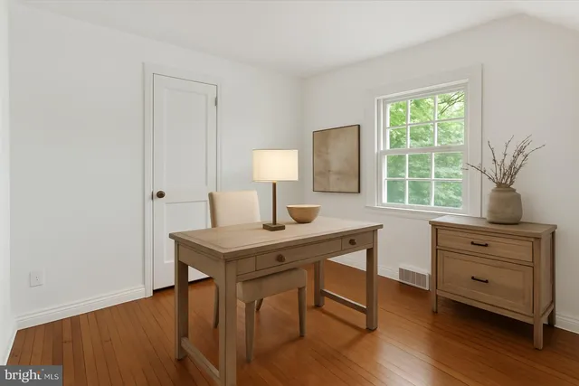 a view of a workspace with furniture and a window
