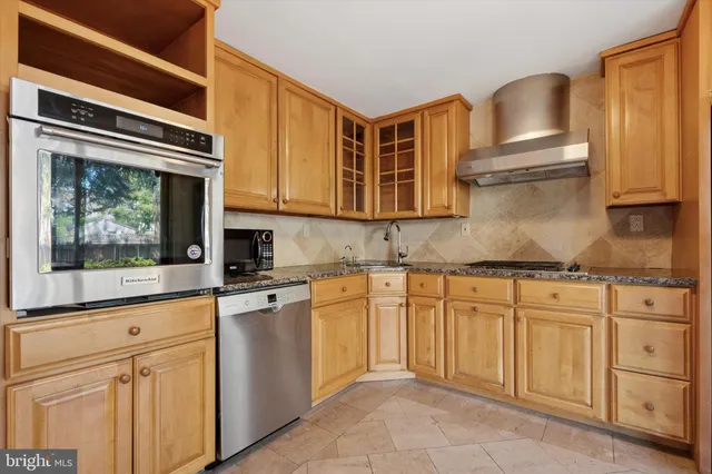 a kitchen with granite countertop stainless steel appliances a stove and a microwave