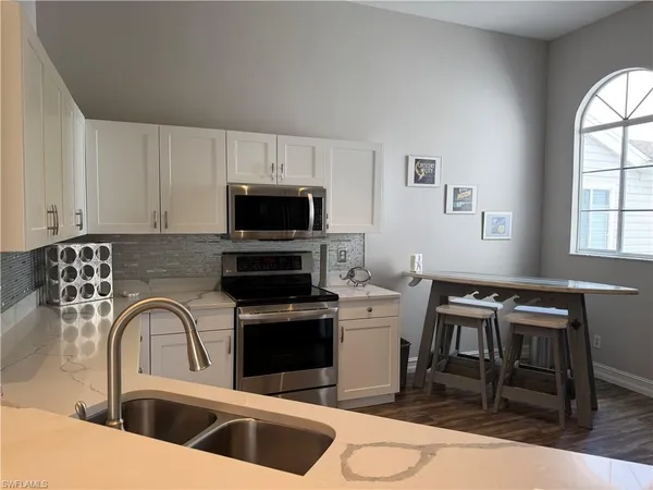 a kitchen with a sink cabinets and dining table chair