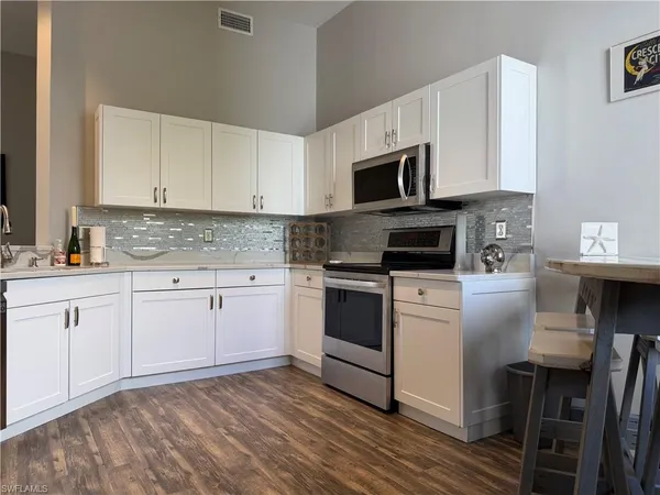 a kitchen with cabinets stainless steel appliances and sink
