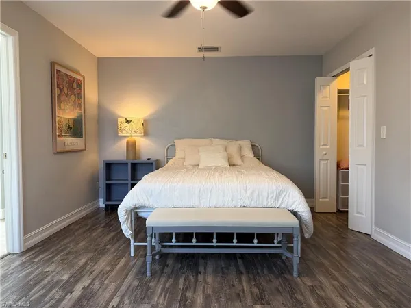 a bed sitting in a bedroom next to a window and a chandelier