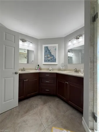 a bathroom with a granite countertop double vanity sink and mirror