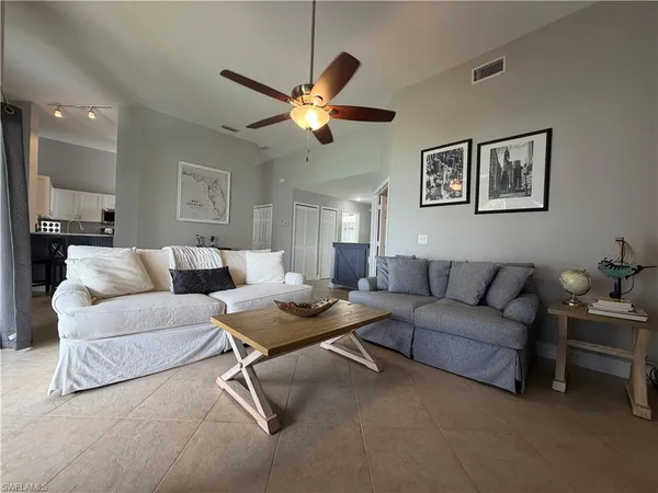 a living room with furniture a window and a ceiling fan