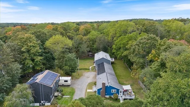 an aerial view of a house with a yard and lake view