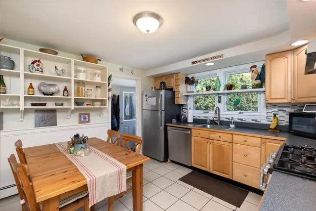 a kitchen that has a lot of cabinets a sink and a dining table view
