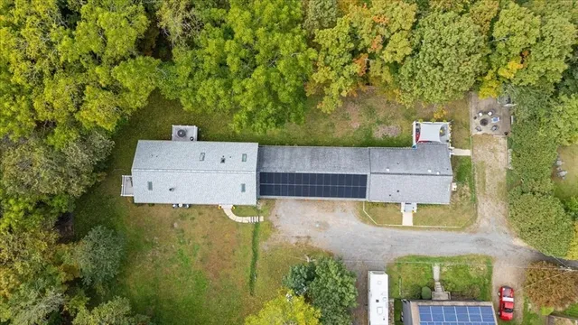 an aerial view of residential house with outdoor space and trees all around