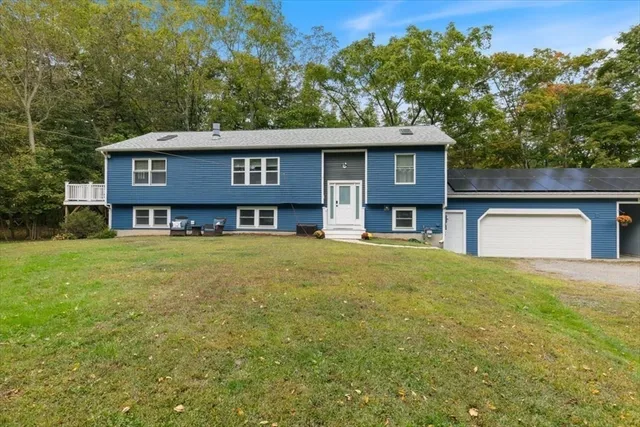 a front view of a house with yard and trees