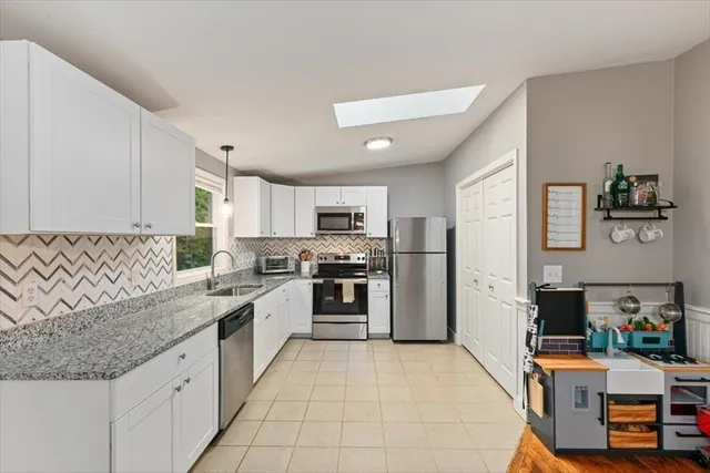 a large kitchen with stainless steel appliances granite countertop a stove and a refrigerator