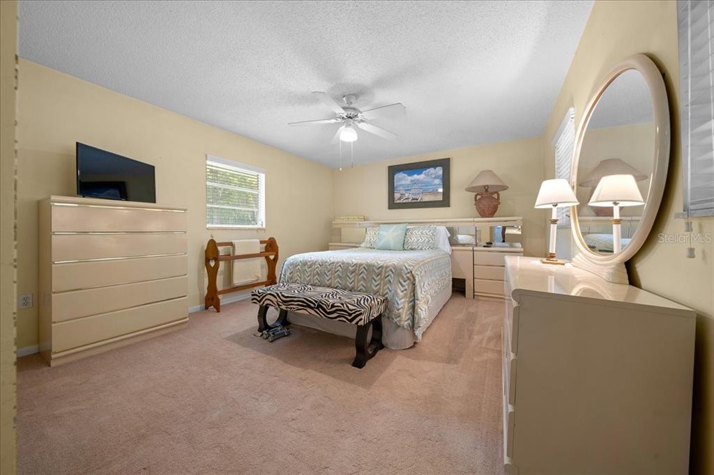 430 Southwest 43rd Place Ocala, FL 34471 - Photo 23 of 83 a spacious bedroom with a bed a mirror and a flat screen tv