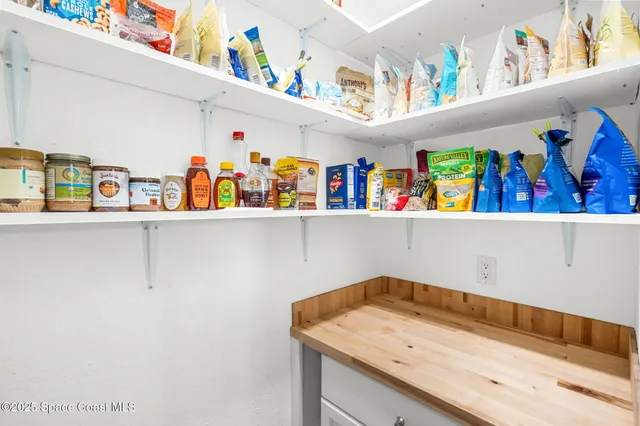 a utility room with lots of clutter and cabinets