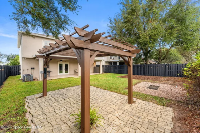 a view of a house with backyard and a tree