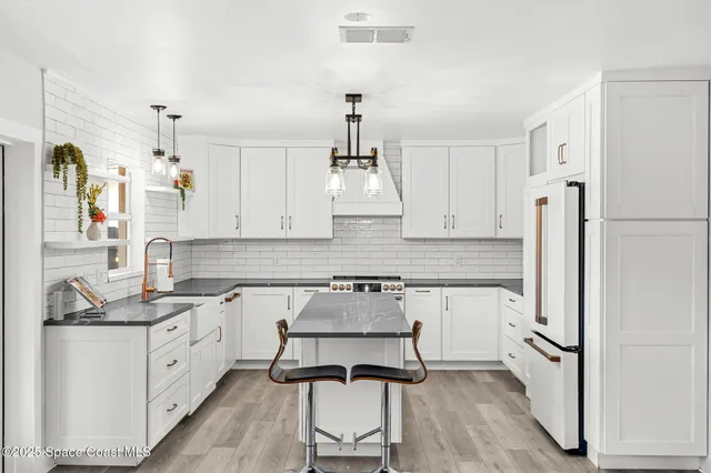 a kitchen with white cabinets and white appliances