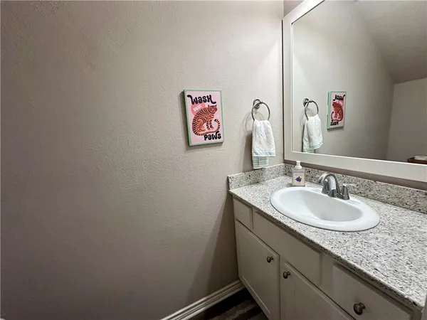 a bathroom with a granite countertop sink and a mirror