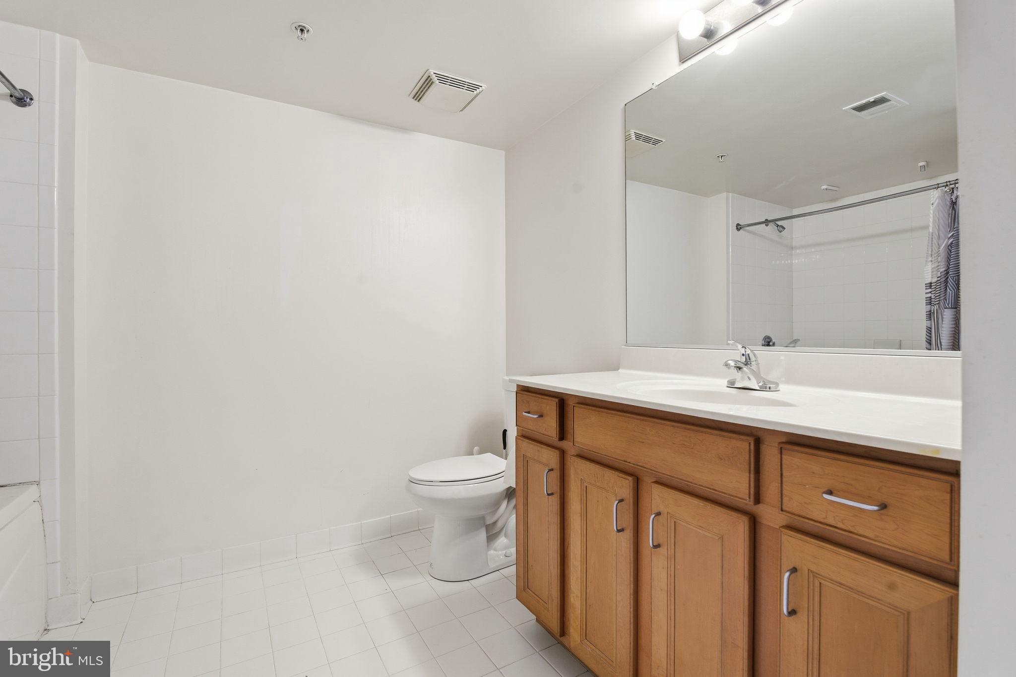 414 Water Street, Unit 1304 Baltimore, MD 21202 - Photo 17 of 24 a bathroom with a sink a toilet and a mirror