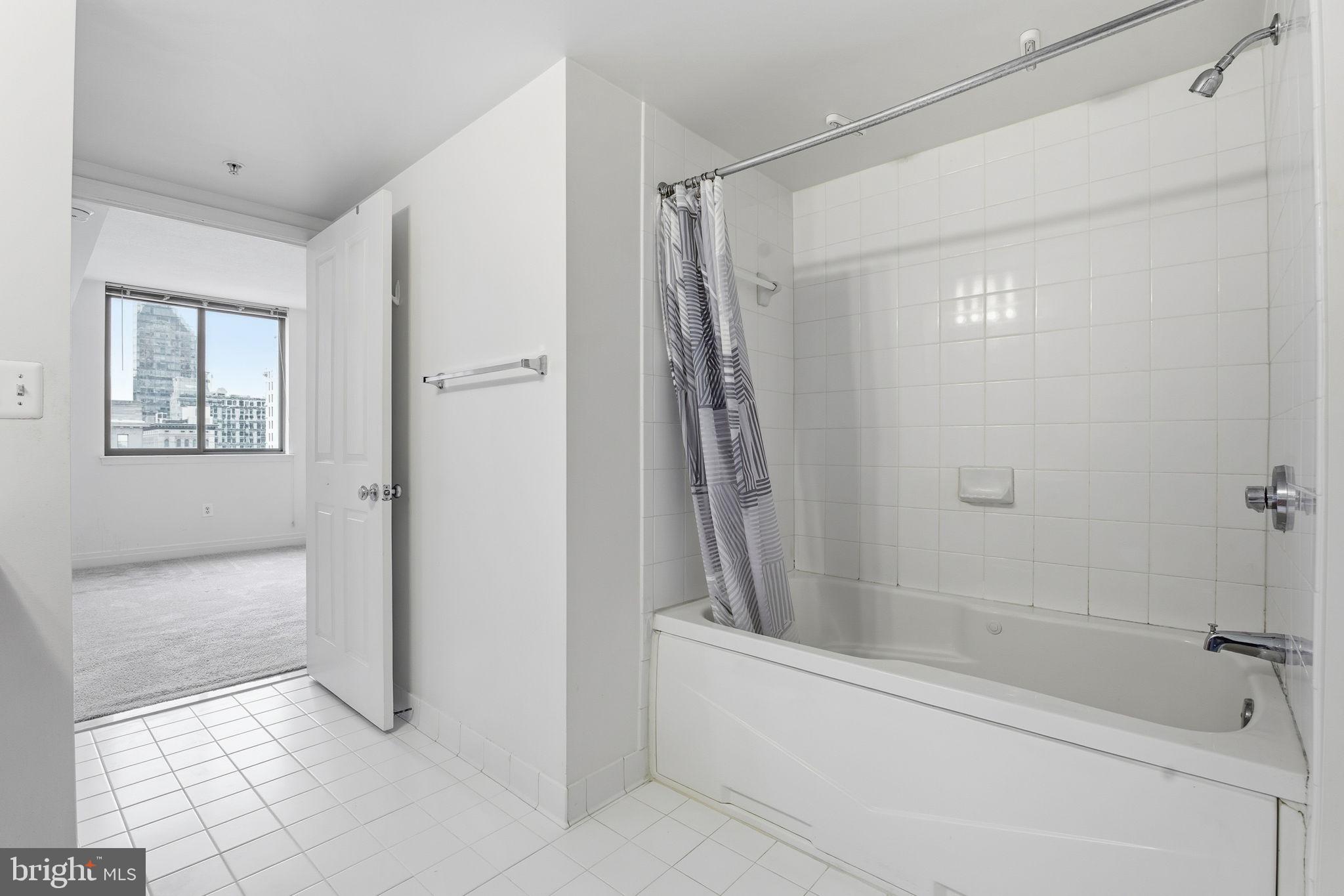 414 Water Street, Unit 1304 Baltimore, MD 21202 - Photo 19 of 24 a bathroom with a bathtub and a shower