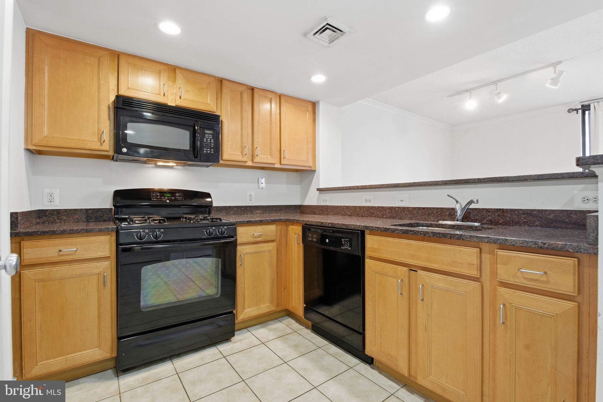 414 Water Street, Unit 1304 Baltimore, MD 21202 - Photo 7 of 24 a kitchen with stainless steel appliances granite countertop a stove a sink and a microwave