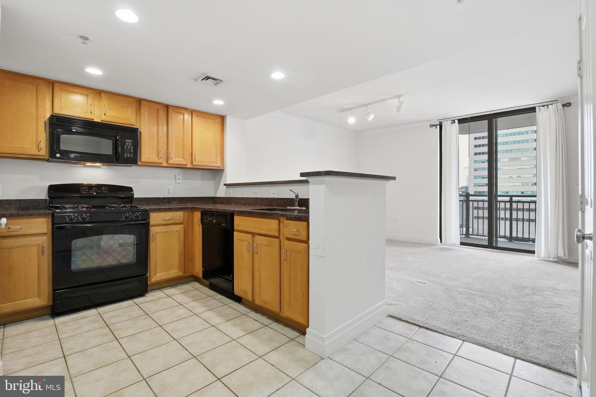 414 Water Street, Unit 1304 Baltimore, MD 21202 - Photo 8 of 24 a kitchen with stainless steel appliances granite countertop a stove a sink and a microwave