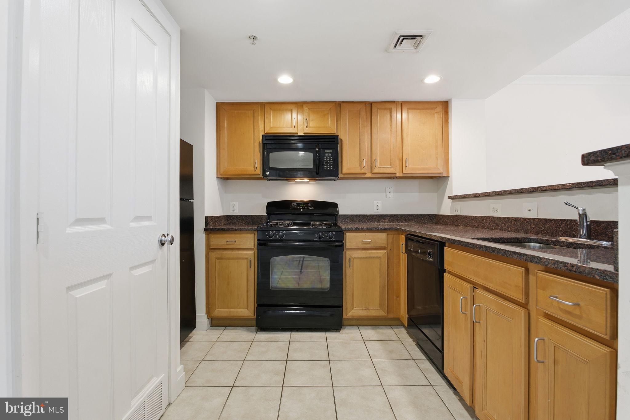 414 Water Street, Unit 1304 Baltimore, MD 21202 - Photo 10 of 24 a kitchen with a sink a stove and cabinets