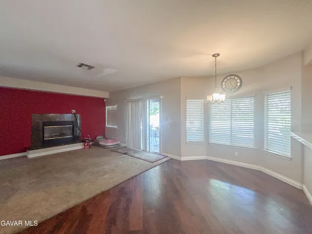 an empty room with windows and fireplace
