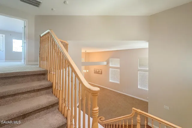 a view of staircase with lots of frames on wall and a window