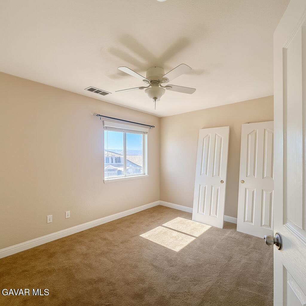 4011 Dee Dee Court Lancaster, CA 93536 - Photo 23 of 41 an empty room with a ceiling fan and window