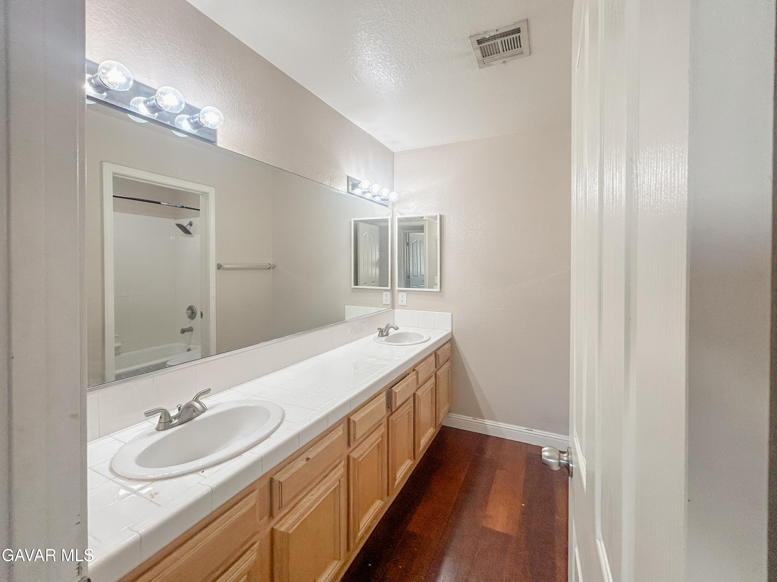 4011 Dee Dee Court Lancaster, CA 93536 - Photo 26 of 41 a bathroom with a double vanity sink and a mirror