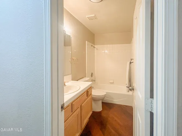 a bathroom with a double vanity sink toilet mirror and bathtub