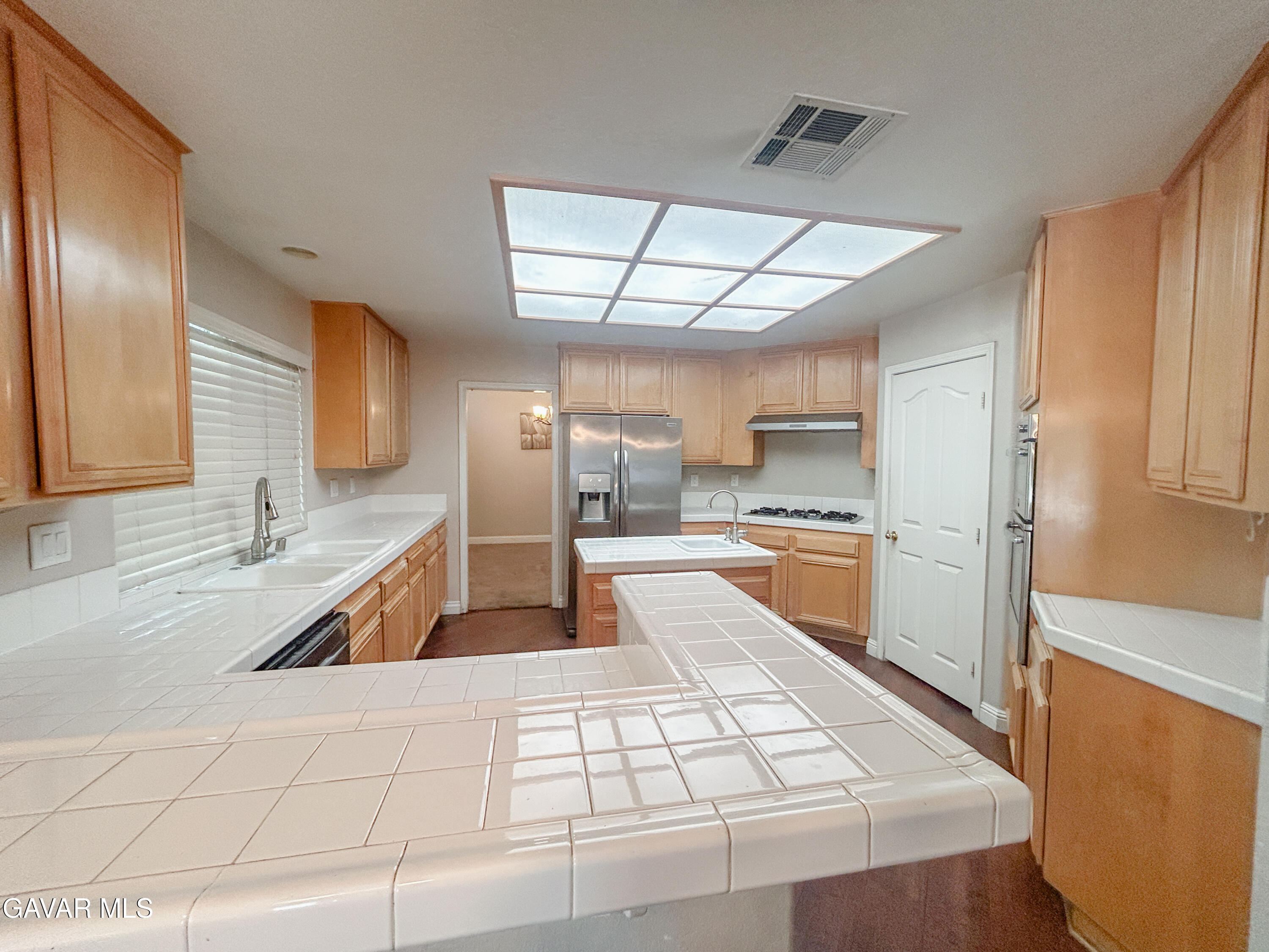 4011 Dee Dee Court Lancaster, CA 93536 - Photo 6 of 41 a large white kitchen with a large window and stainless steel appliances