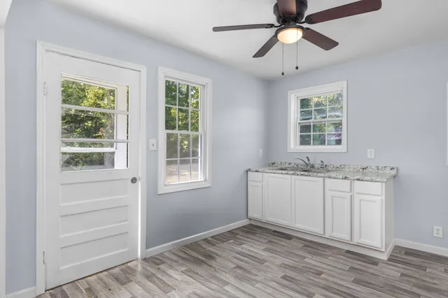 a room view with wooden floor and windows