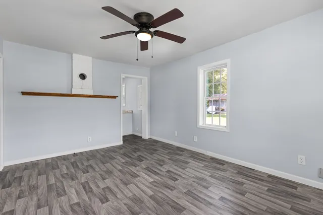 an empty room with a window and a fan