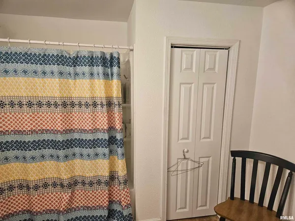 a bathroom with a granite countertop shower and a tub
