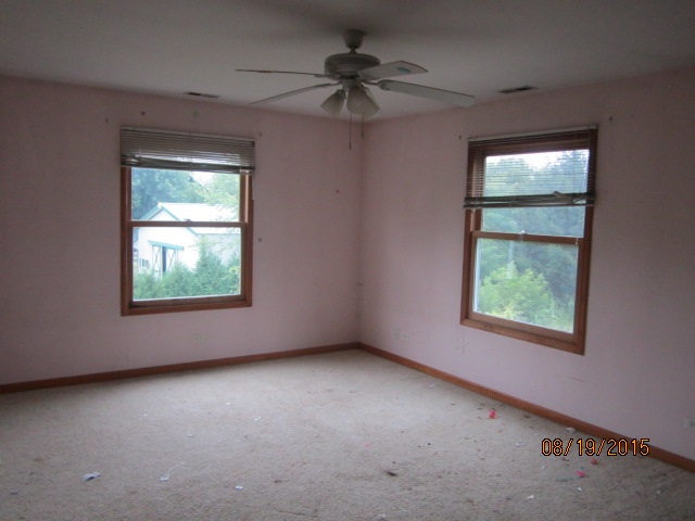 19105 McGuire Road Harvard, IL 60033 - Photo 15 of 16 an empty room with windows and fan