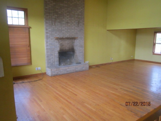 19105 McGuire Road Harvard, IL 60033 - Photo 6 of 16 a view of an empty room with a fireplace and a window