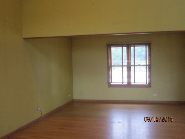 19105 McGuire Road Harvard, IL 60033 - Photo 7 of 16 an empty room with wooden floor and windows