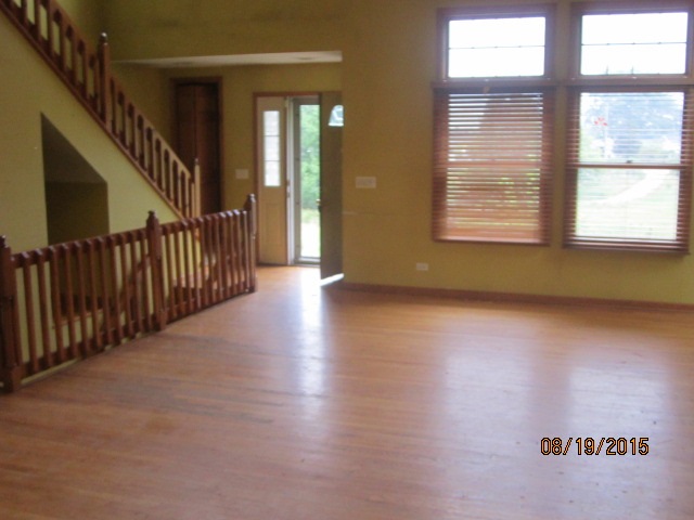 19105 McGuire Road Harvard, IL 60033 - Photo 8 of 16 a view of a hallway with wooden floor and windows
