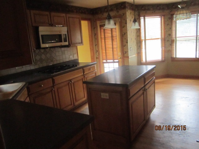 19105 McGuire Road Harvard, IL 60033 - Photo 10 of 16 a kitchen with stainless steel appliances a stove a microwave a sink and cabinets